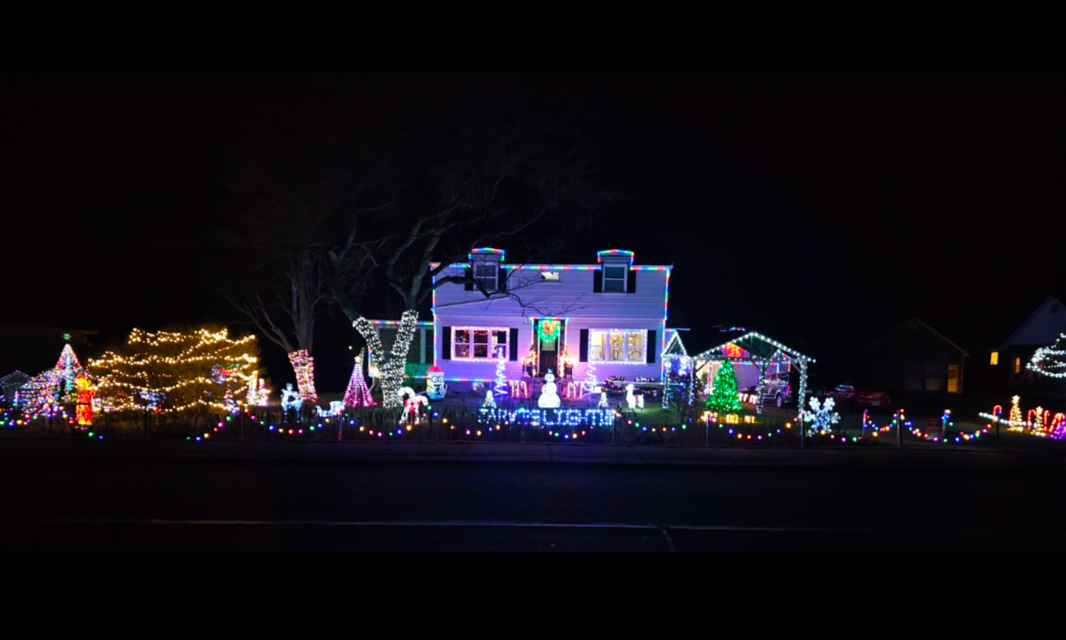 a decorated house with yard full of lighted decorations